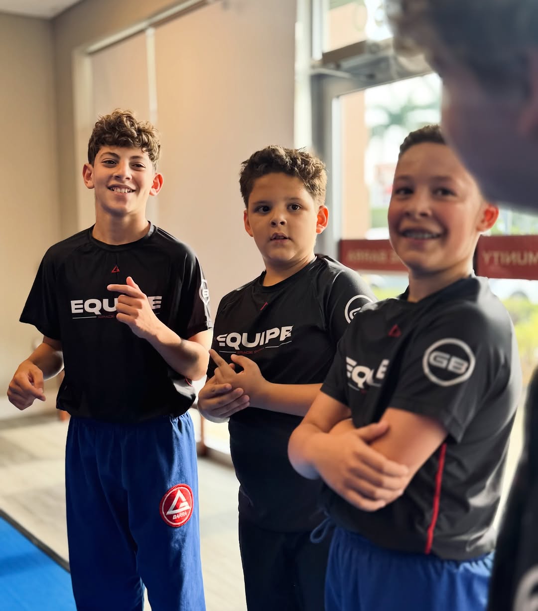 Three students posing beside the mats at GB Coral Springs