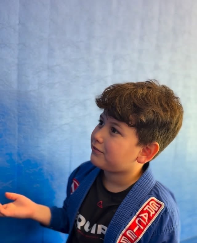A child seated in a blue gi at GB Coral Springs